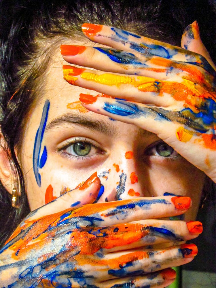 Woman With Paints On Face And Hands
