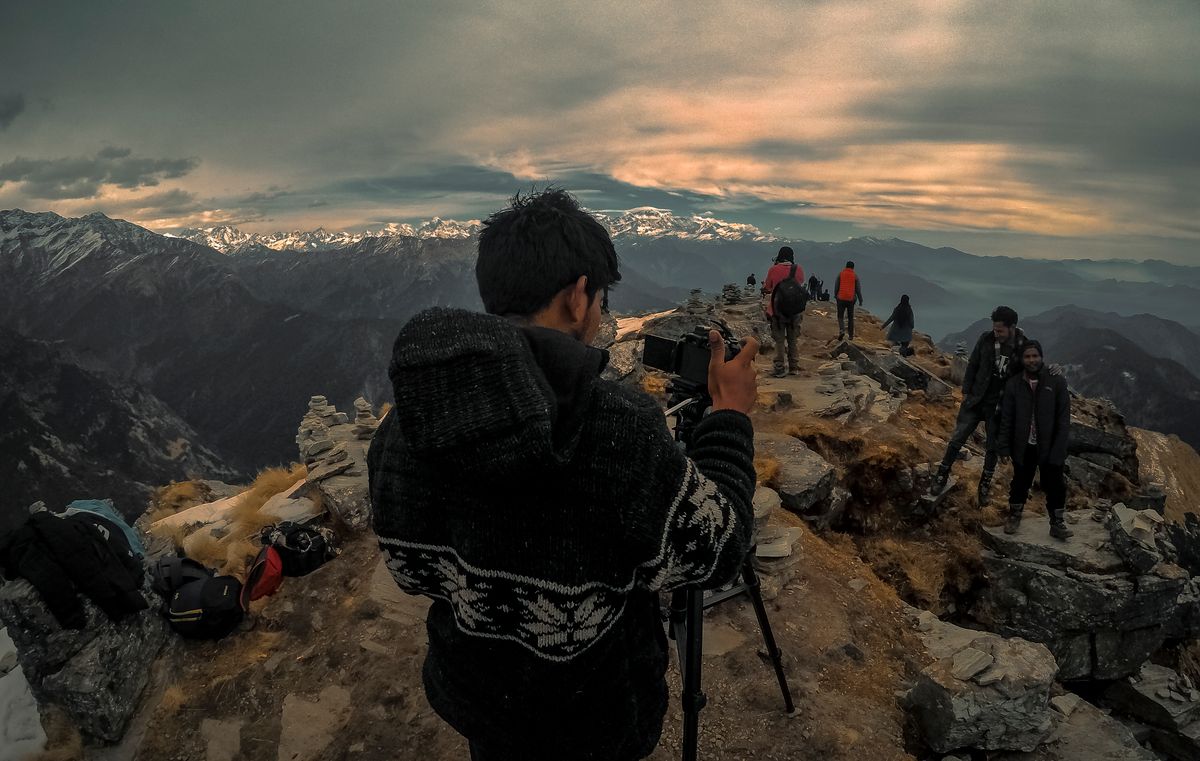 Photographer with a tripod on a mountain ridge