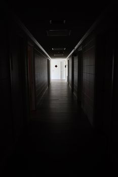 A dark and empty hallway indoors leading to a closed door, creating an eerie atmosphere.. pexels, dark, empty