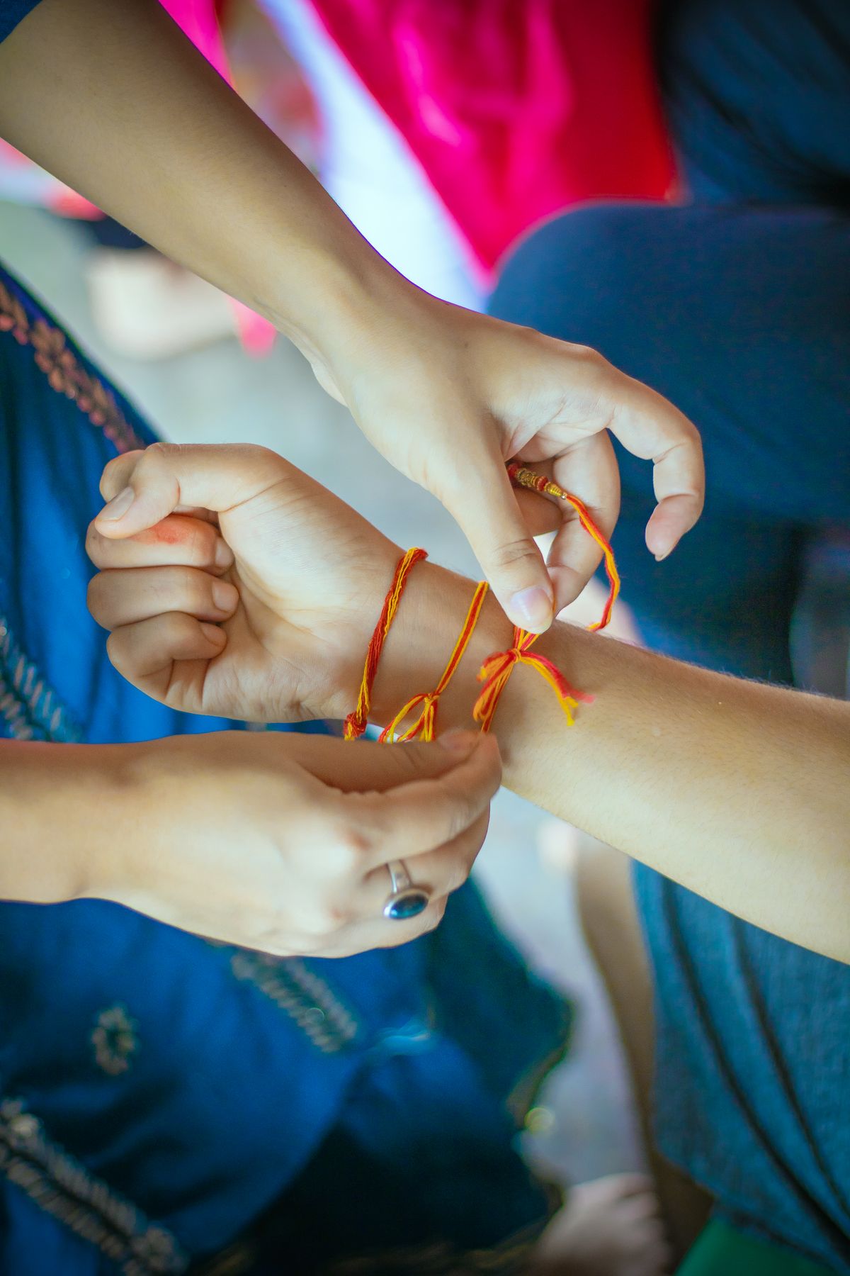 Hands tying friendship string bracelets