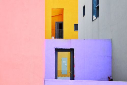 Free Colorful geometric building facade with door and windows, showcasing modern architecture. Stock Photo