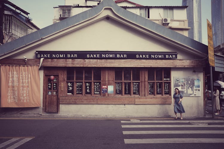 Bar Building And Woman Crossing Street