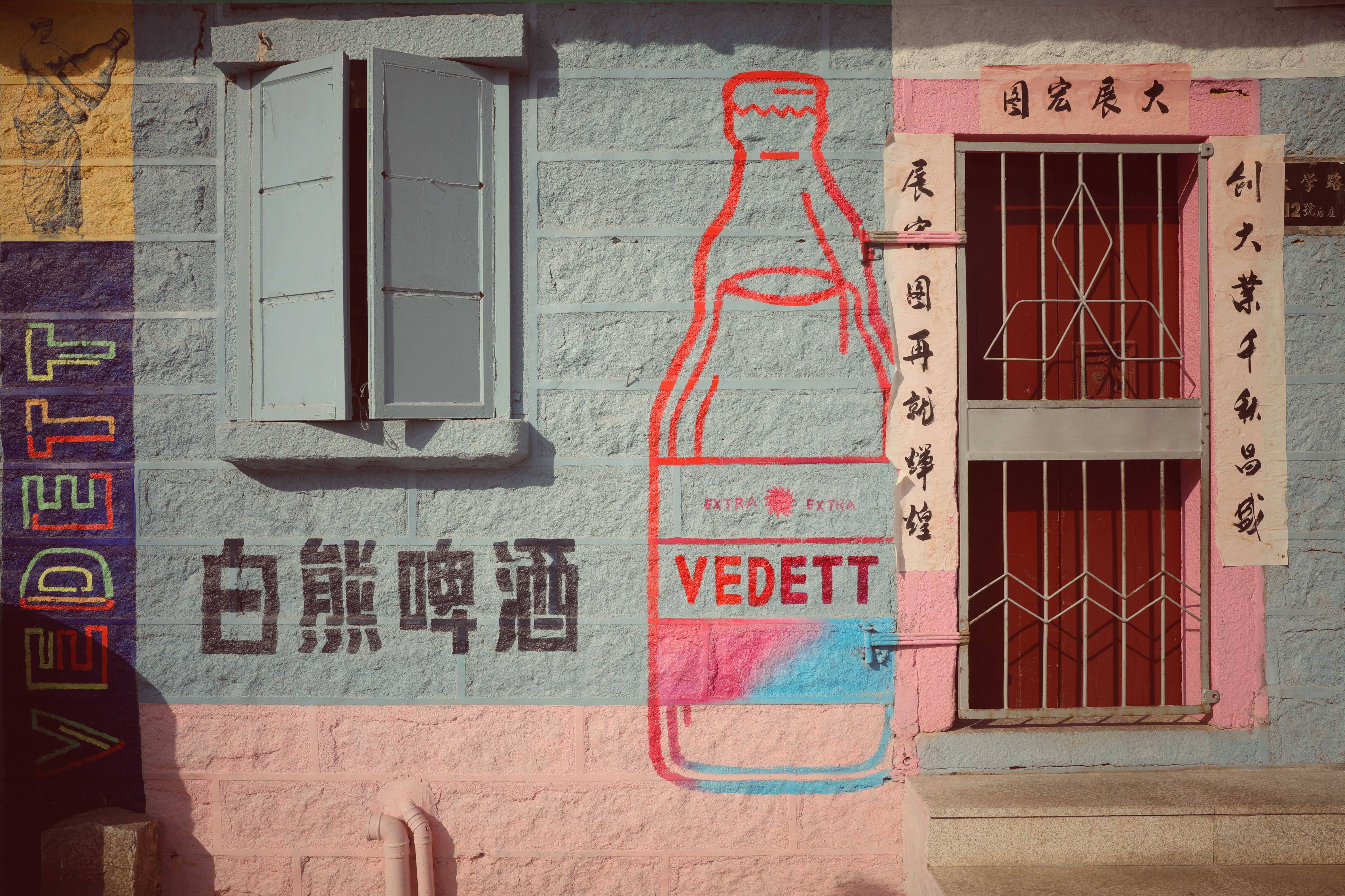Vibrant mural depicting a large bottle and text on an urban wall. Cultural and artistic expression.