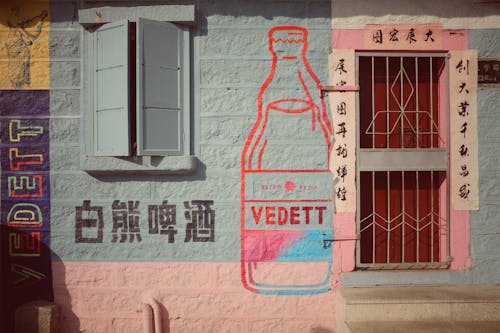 Colourful Facade of a Building with a Painting of a Bottle and Chinese Writing 