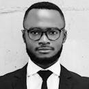 这张黑白照片风格优雅，照片中一位戴眼镜、西装革履的男子展现出十足的现代感