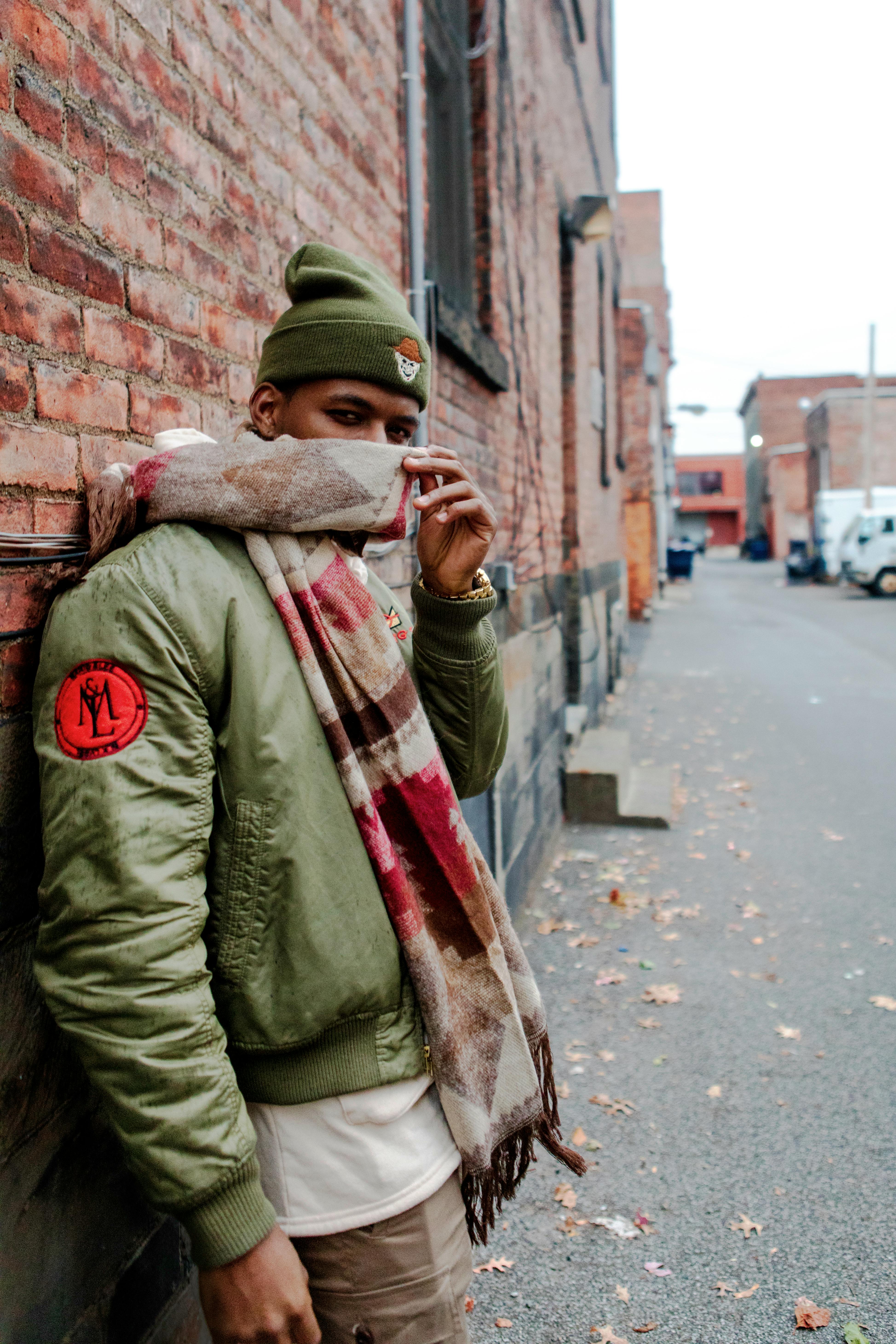 一名穿着休闲冬装的男子在城市砖砌小巷里摆姿势