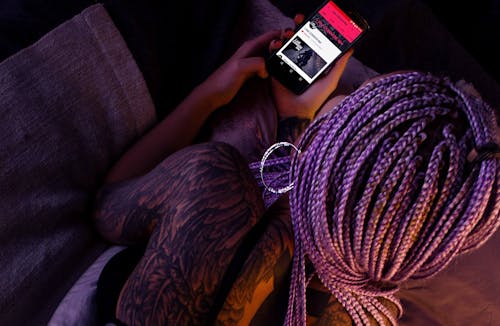 Free Woman with Purple Braided Hair Holding an Android Smartphone Stock Photo