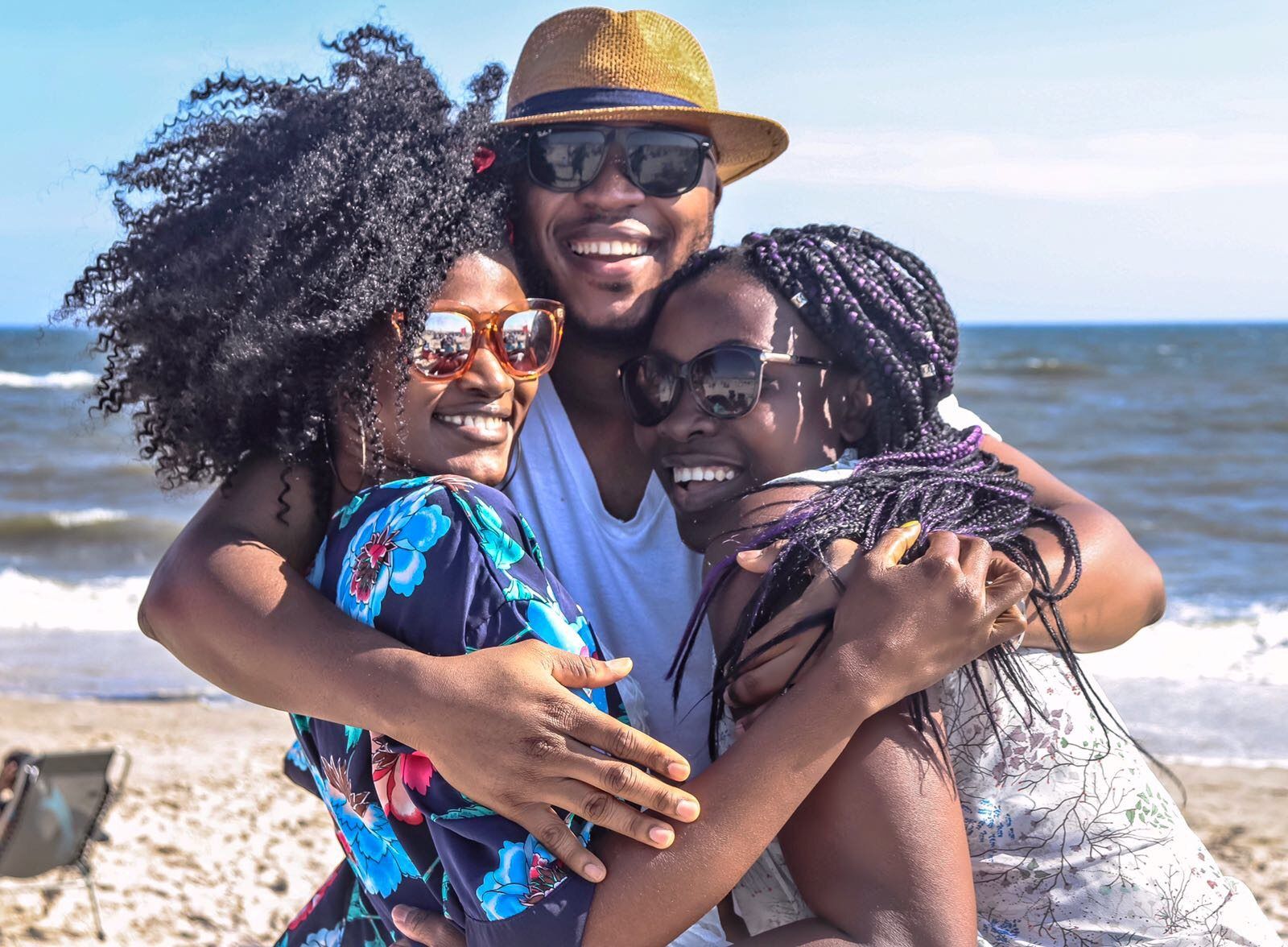 Seeman Hugging Two Women With Man Hugging by the Sea · Free Stock Photo