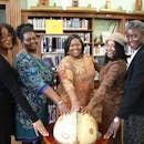 五名女性聚集在图书馆，象征着团结与教育