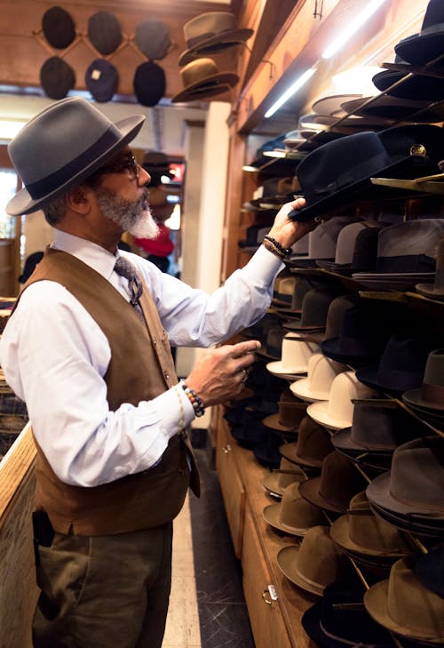 Free Man Picking Hats in Rack Stock Photo