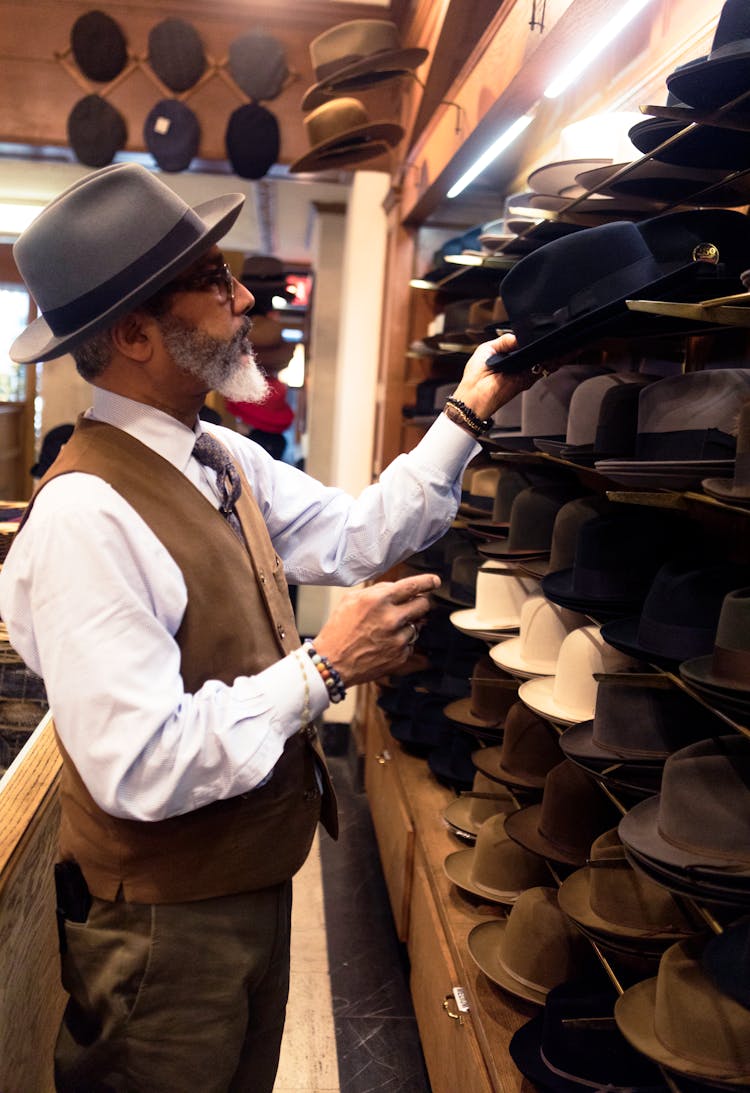 Man Picking Hats In Rack