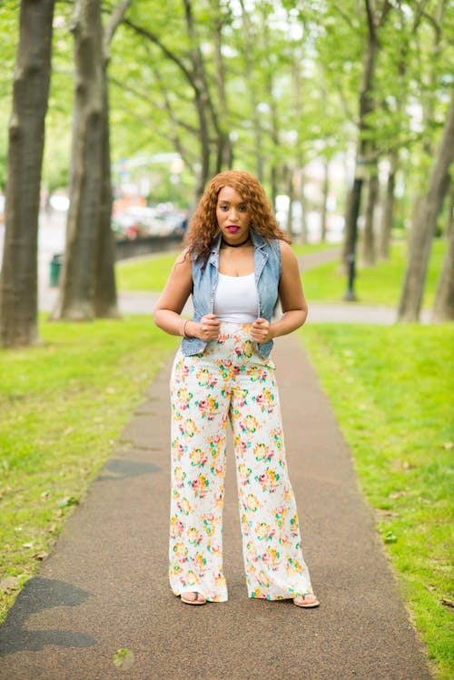 Woman in White Shirt with Denim Vest and Floral Pants