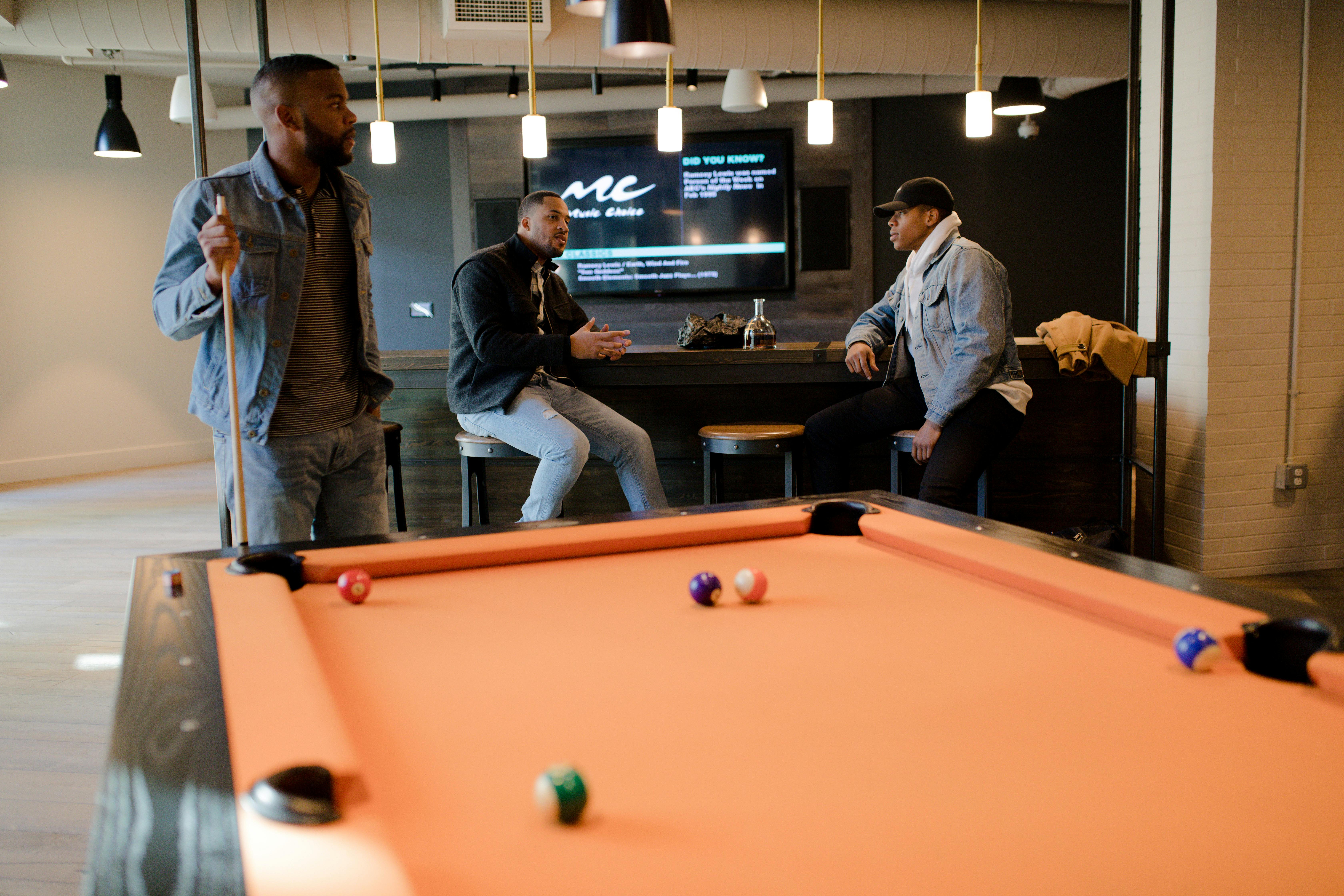 Man Playing Pool Table While Sharply Looking at the White Ball on the Table \u00b7 Free Stock Photo