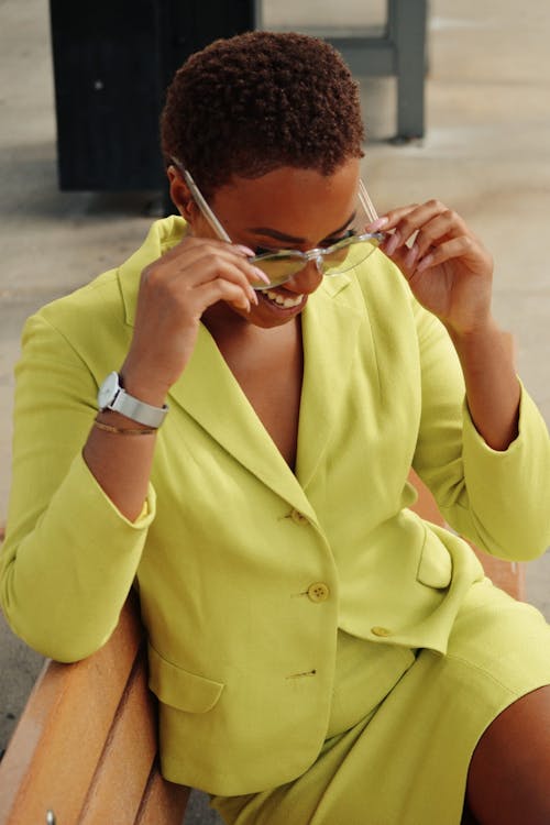 Femme Tenant Des Lunettes De Soleil Assis Sur Un Banc