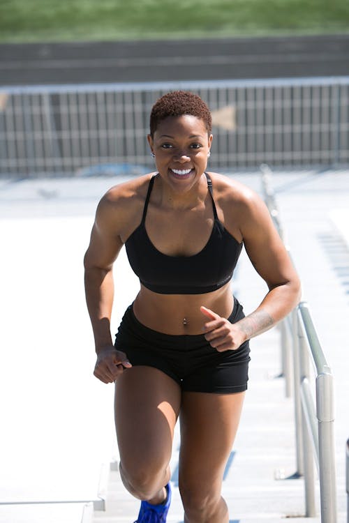 Mujer Vestida Con Sujetador Deportivo Negro Y Pantalones Cortos Jogger Sonriendo