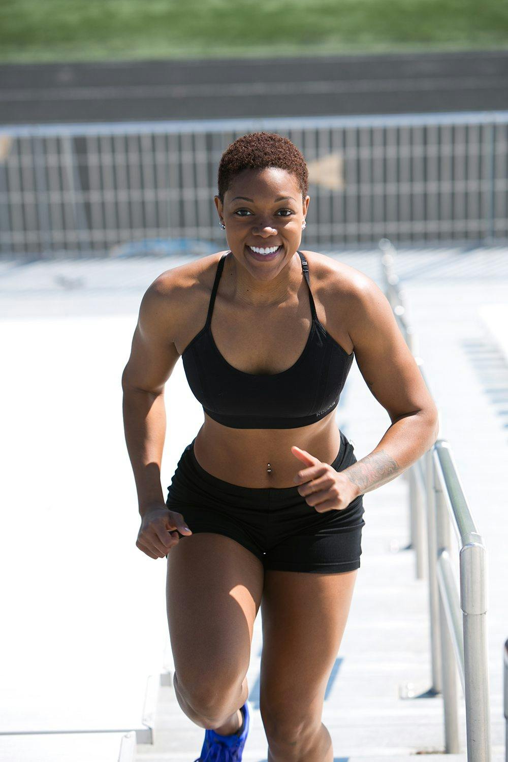 Woman Wearing Black Sports Bra and Jogger Shorts Smiling · Free Stock Photo