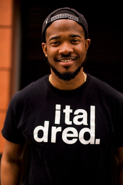 Smiling Man Wearing Black Snapback Cap and Black Crew-neck Shirt