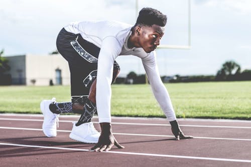 Homme Portant Un Pull Blanc Et Un Short Noir Sur Le Point De Courir