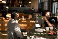 两名成年人在现代化的室内环境中随意喝着饮料会面