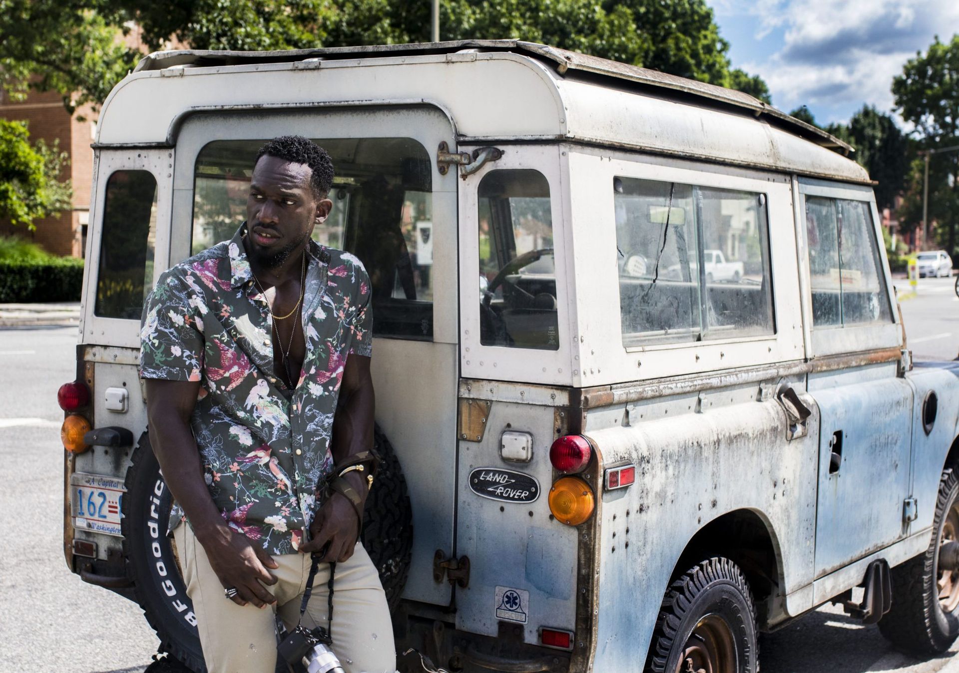 Man Stands Near White Land Rover Defender at Daytime
