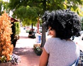 一位快乐的卷发年轻女子在户外享受阳光明媚的一天