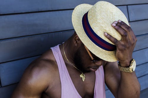 Man Wearing Purple Tank Top, Gold-colored Necklace, Gold-colored Watch, Sunglasses, and Beige Fedora Hat Outfit