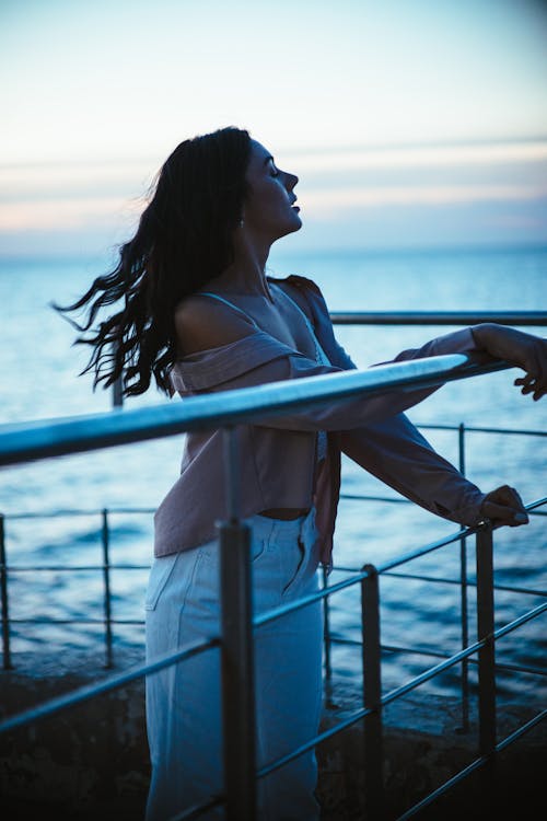 Woman Holding on Metal Railing