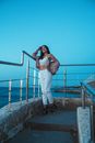 Woman in Bralette and Pants Posing Near Metal Railings