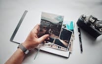 桌子上有一个人拿着老式相机和笔记本的照片