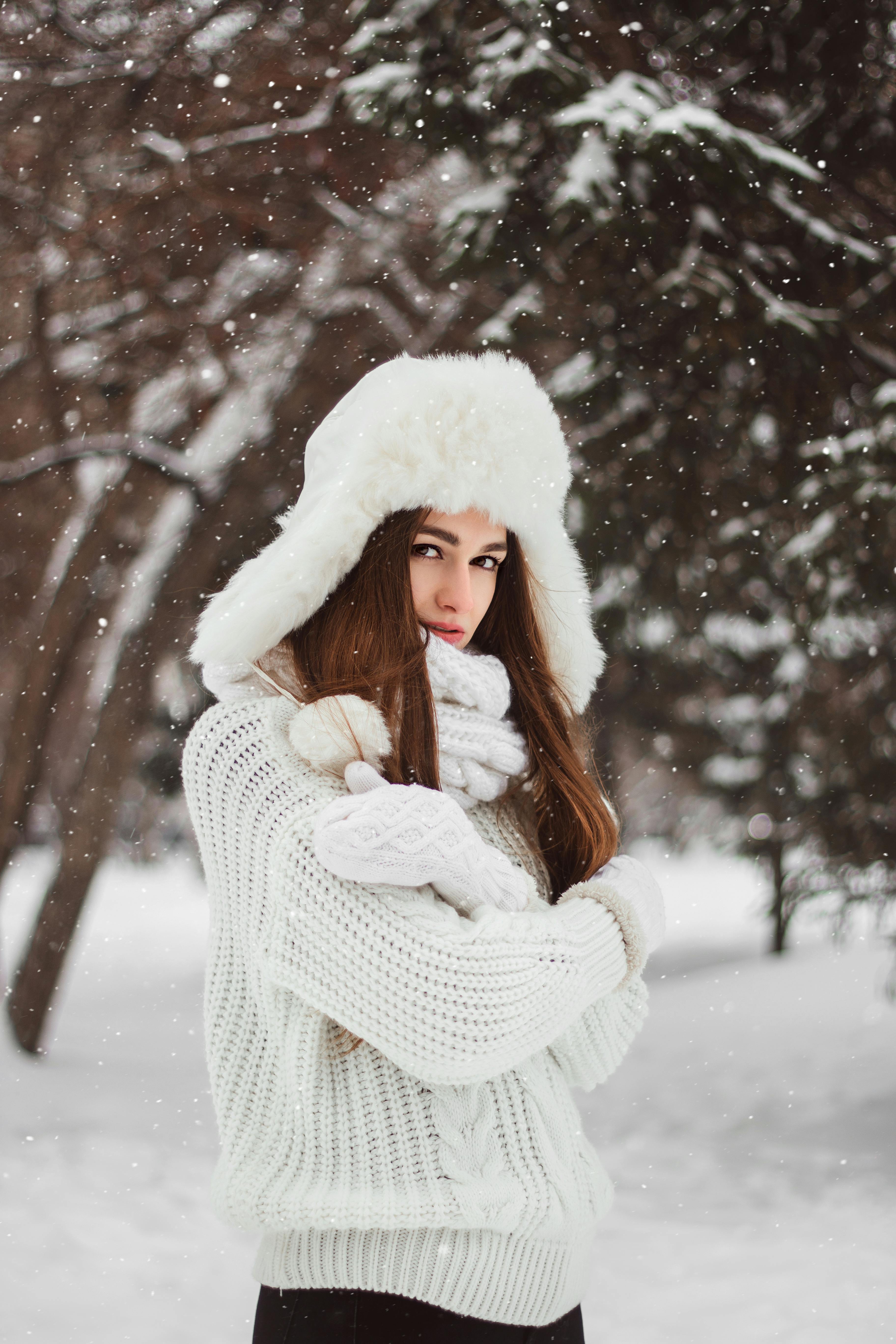 Winter fashion. Beautiful female model is wearing white winter