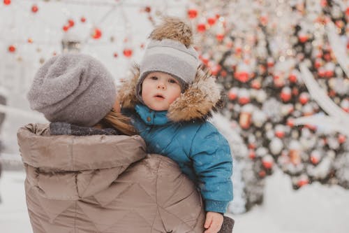 A Mother Carrying Her Daughter Out in the Snow