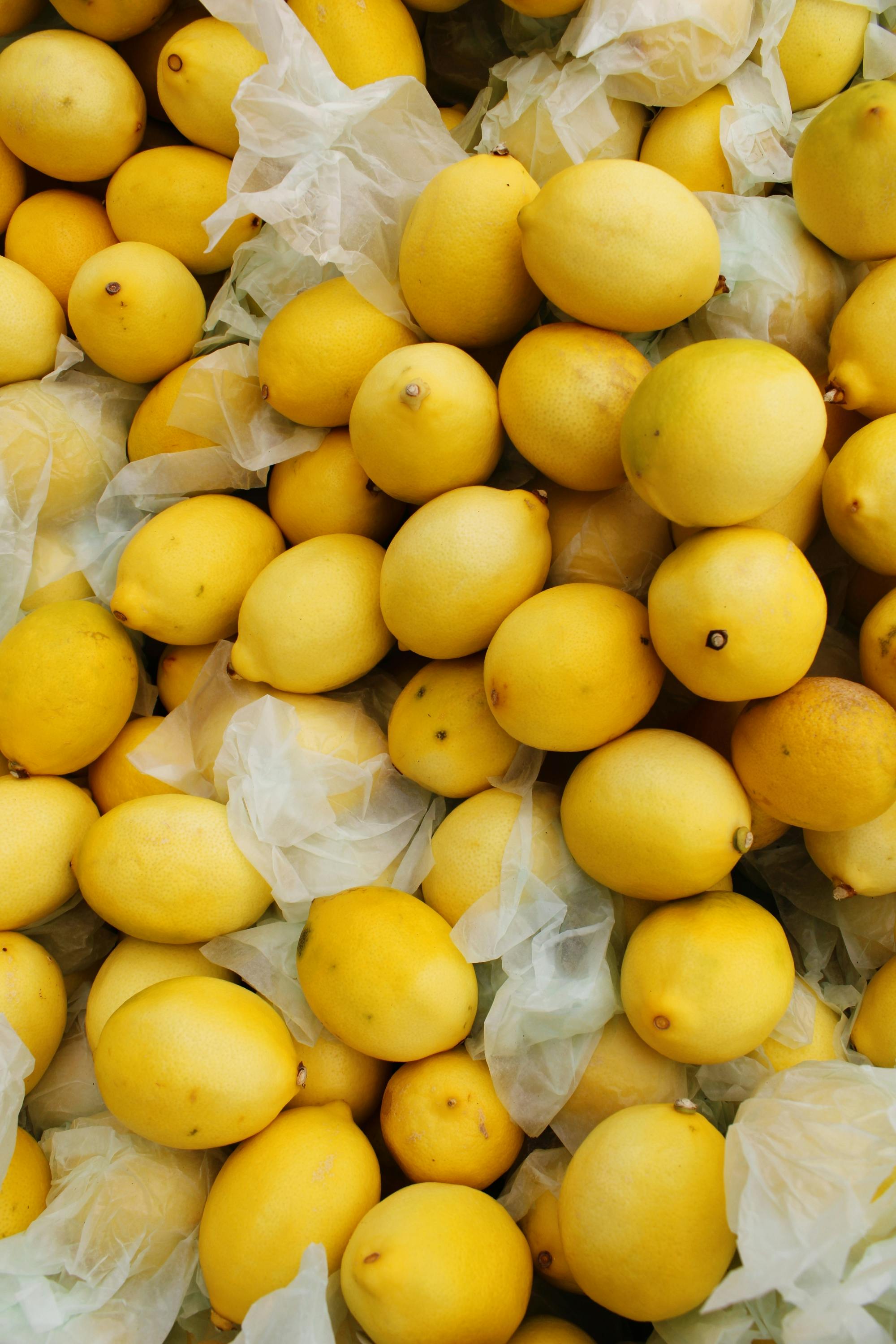Vibrant yellow lemons piled together, ideal for healthy diet concepts in fresh market scenes.