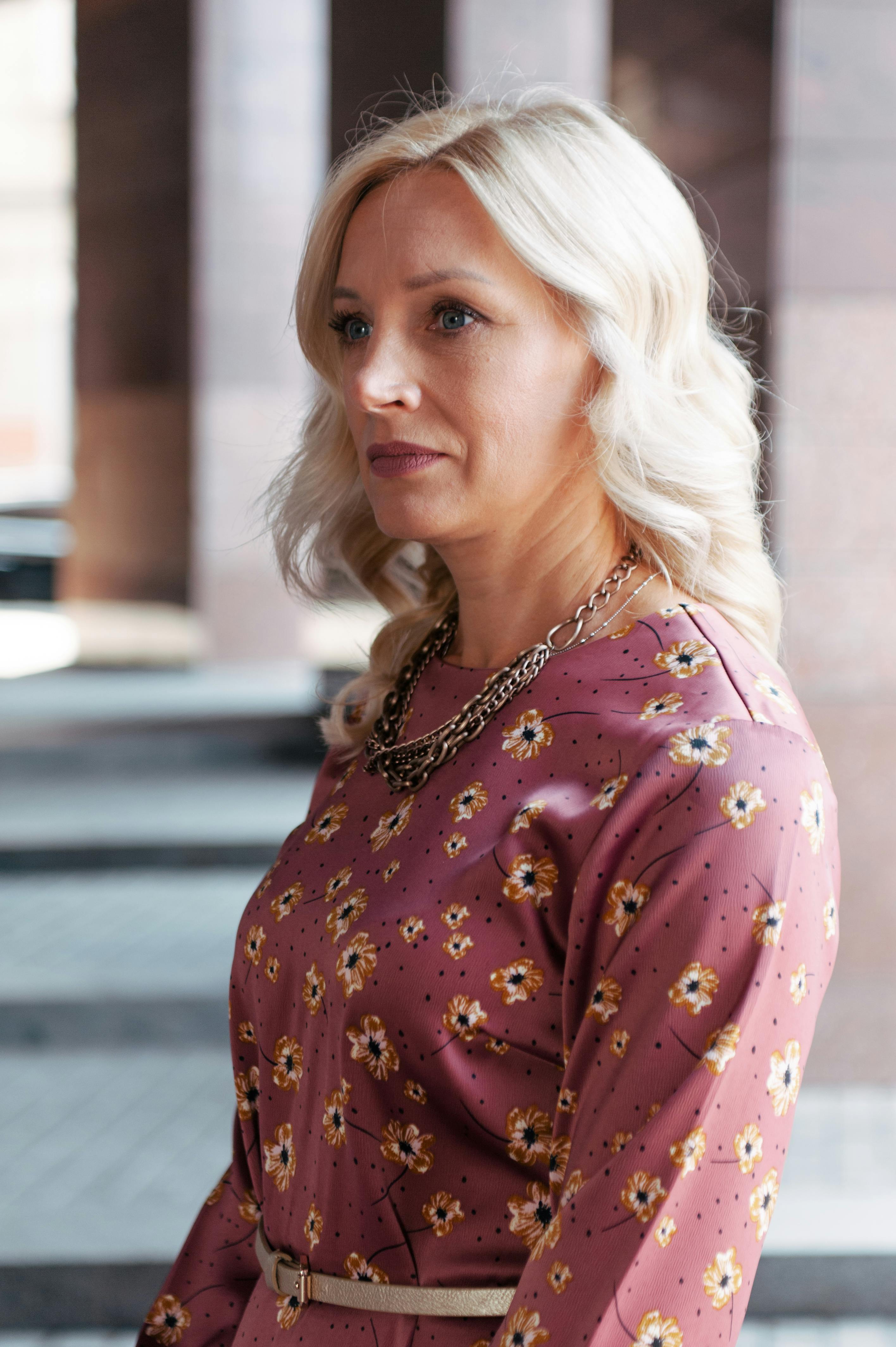 Profile of an elegant woman in a floral dress during the day.
