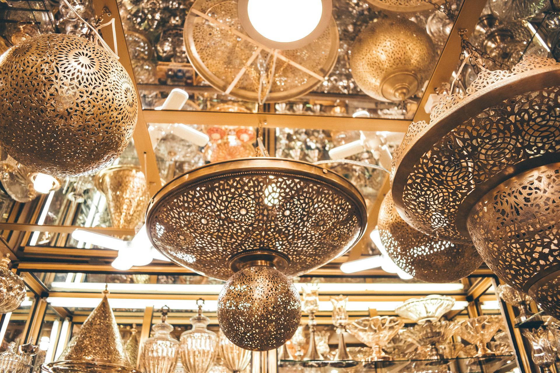 Intricate Moroccan lanterns hanging in a Fes interior design shop, showcasing traditional artisan craftsmanship.