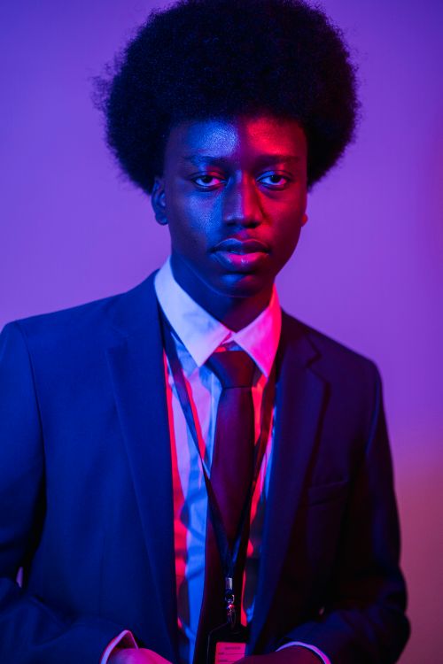 Free Modern portrait of an African American man in a suit with vibrant lighting. Stock Photo
