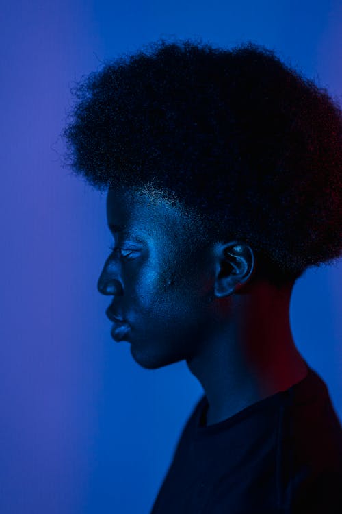 Photos gratuites de afro, arrière-plan bleu, chemise noire