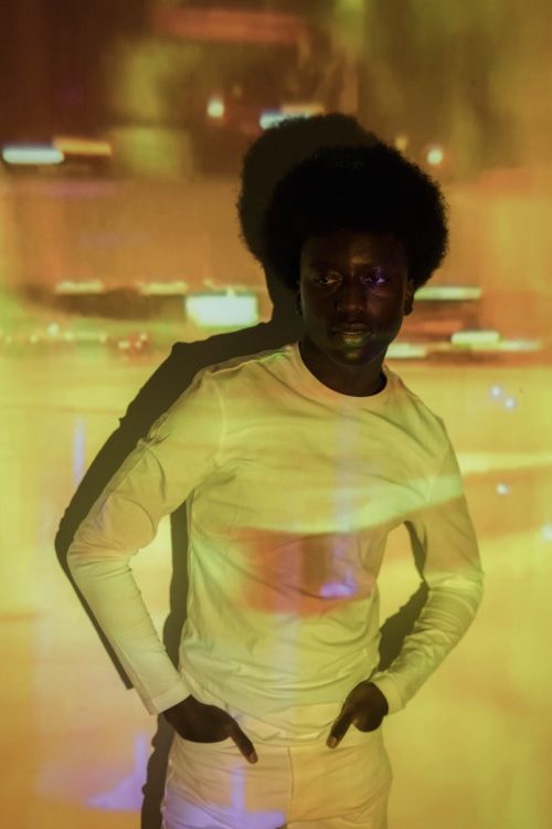 Free Creative studio portrait of a black man with yellow light projections. Stock Photo