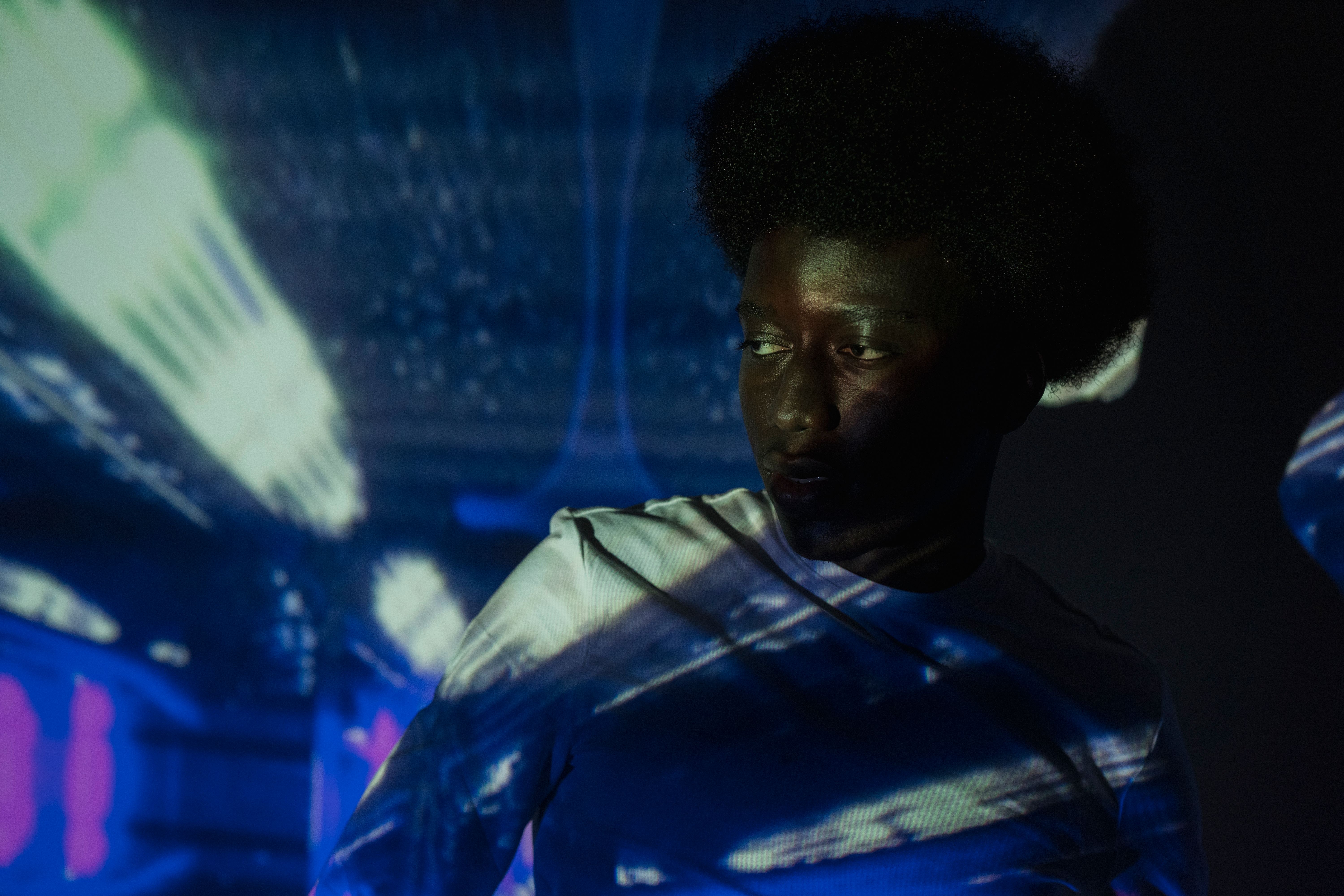 A modern portrait of a man illuminated by futuristic light projections, creating a dynamic effect.