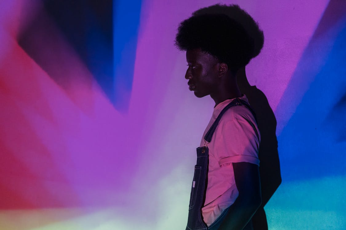 
Man in Violet Crew Neck T Shirt and Blue Overalls in Colorful Background