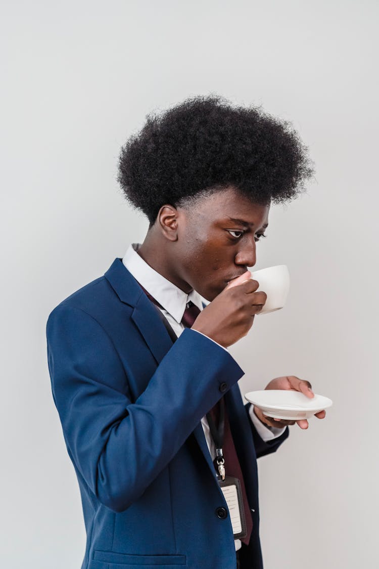 Curly-Haired Boy In Blue Suit Drinking Coffee