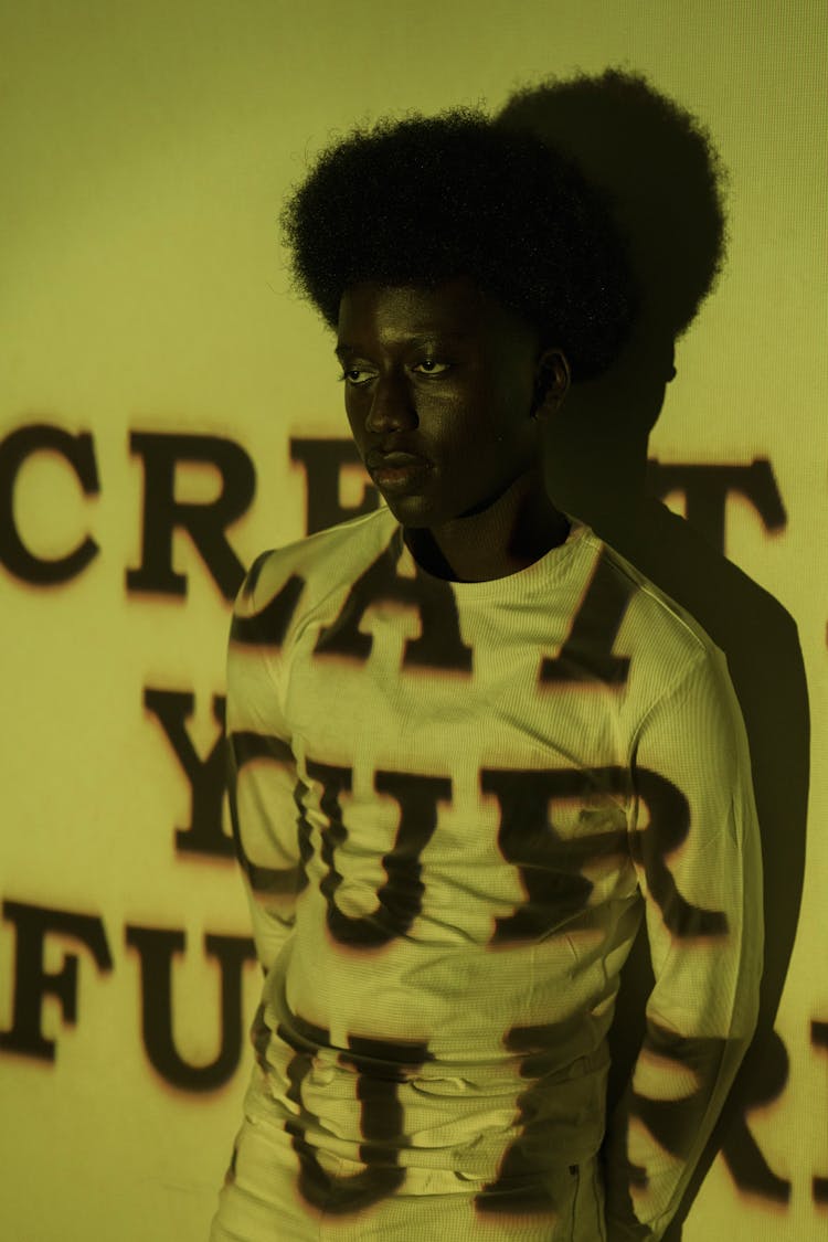 Projector Displaying Letters On A Young Man At A Photoshoot 