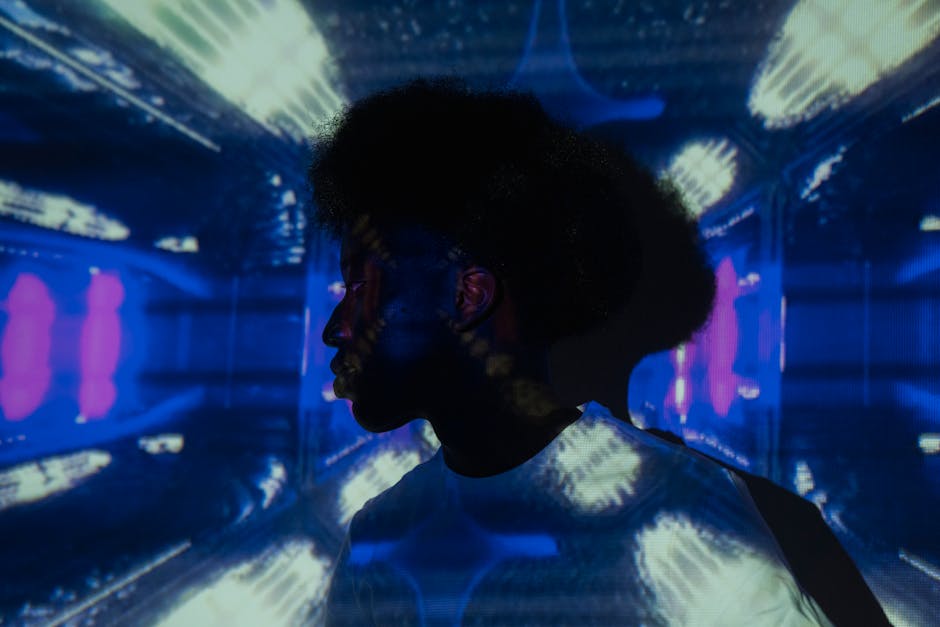 Colorful silhouette of a man surrounded by vibrant light patterns from a projector.