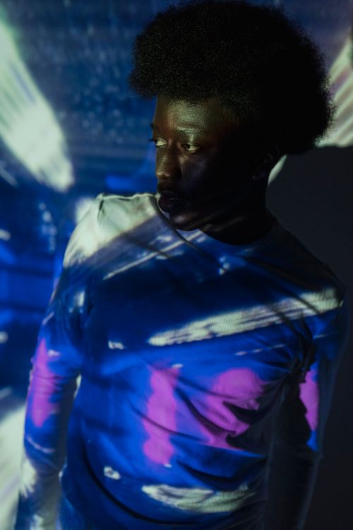 Free Artistic studio portrait with vibrant light projections on a person, creating a dramatic effect. Stock Photo