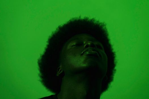 Artistic silhouette of an adult under vibrant green lighting, creating a moody, abstract portrait.