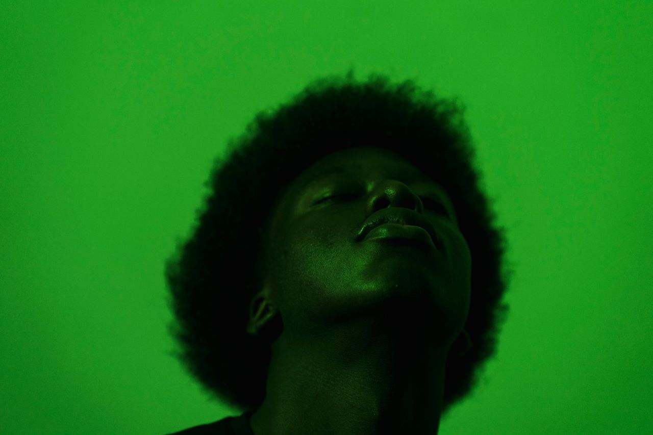 artistic silhouette of an adult under vibrant green lighting creating