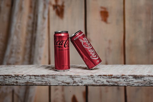 Free Coca Cola Cans on Wooden Plank Stock Photo