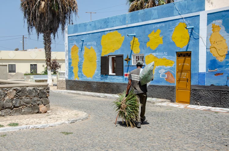 Men With Plants Walking Tropical City Street