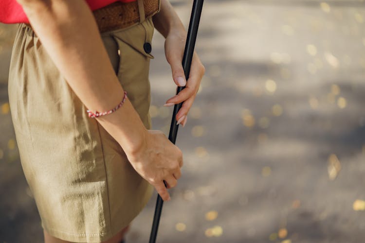 Close-up Of Woman Holding A Black Stick 