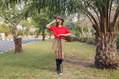 Woman in Red Shirt and Brown Shorts