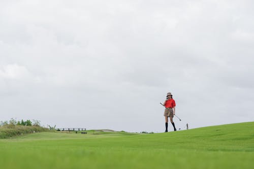 A Golfer Talking on the Phone Under the Cloudy Sky